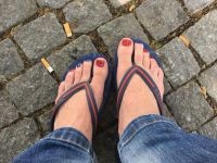 Füße in Flip-Flops mit rot und blau Füsse