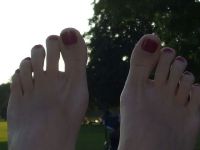 Lila Nagellack Füße im Park Füsse
