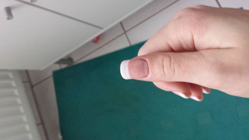 Rechter Daumen von oben mit French-Line Tip-Gelmodellage zum ersten Mal selbst ausprobiert in Anfänger Nageldesign