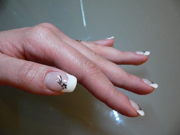 Seitenansicht, den kleinen Finger sieht man schlechter Naturnagelverstärkung French mit Sternsticker in Anfänger Nageldesign