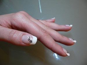 Seitenansicht, den kleinen Finger sieht man schlechter Naturnagelverstärkung French mit Sternsticker in Anfänger Nageldesign